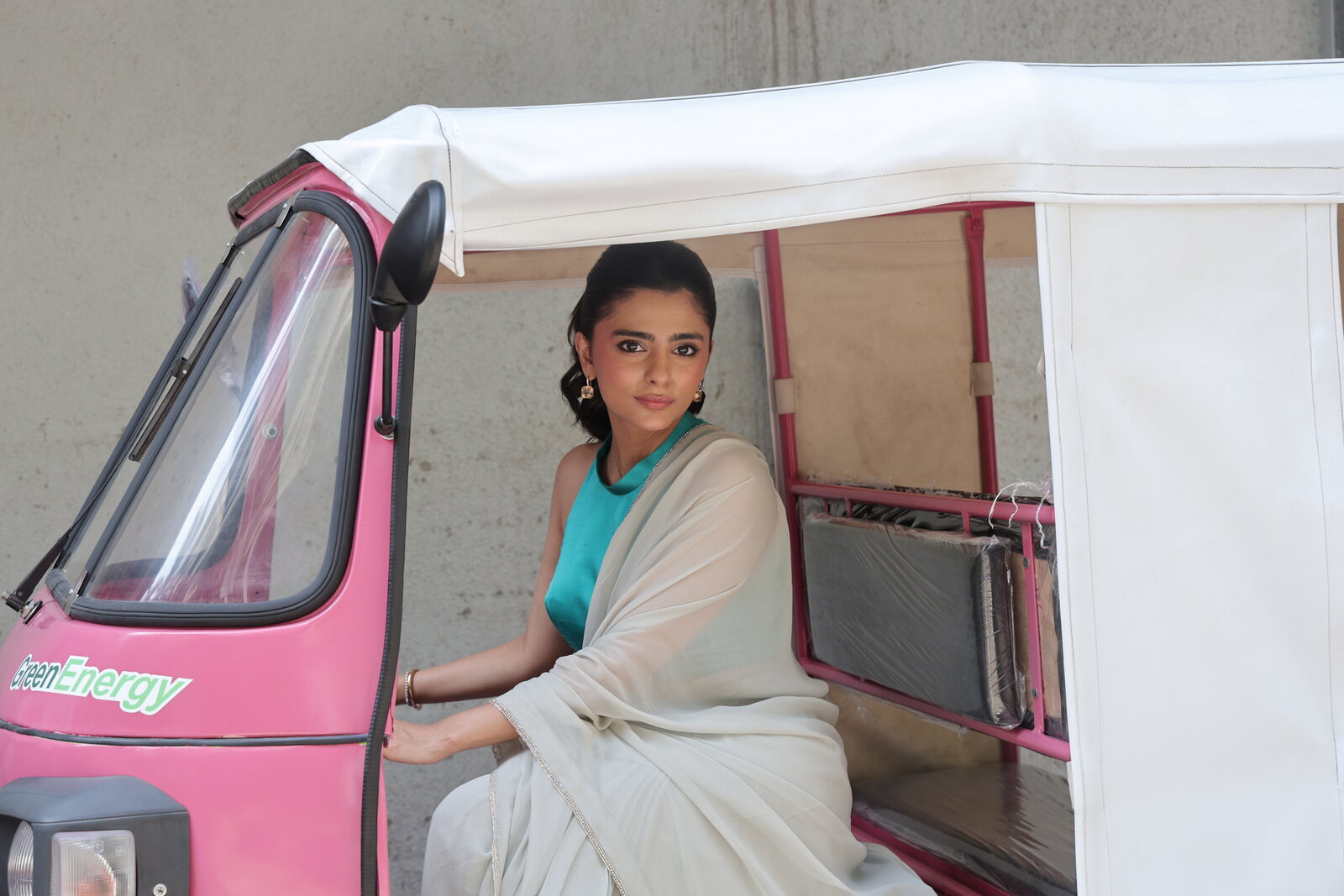 A woman seated inside a pink electric rickshaw during the Pink E-Rickshaw Support Initiative launch
